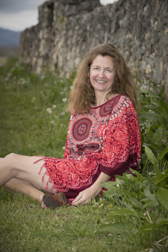 Tunique réalisée à partir d'un paréo thaï de couleur rouge portée par une femme de 50 ans assise dans l'herbe