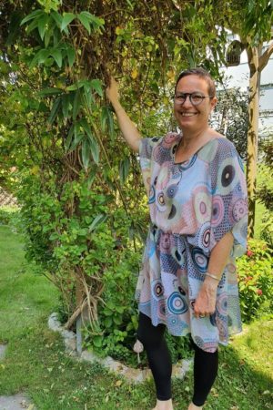 Tunique légère avec un imprimé géométrique, des cercles roses pâles, noirs, beiges, sur fond bleu très clair