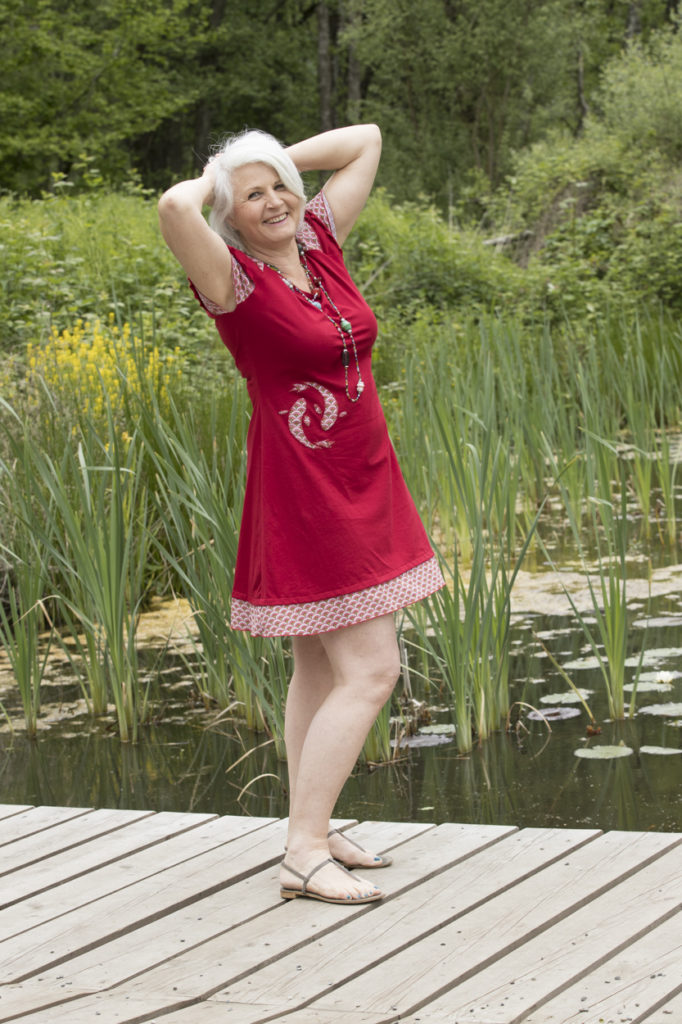 Robe d'été avec un jeu d'uni et d'imprimés aux écailles stylisées se retrouvant aux manches, sur le motif de poissons rouges et sur le bandeau de l'ourlet