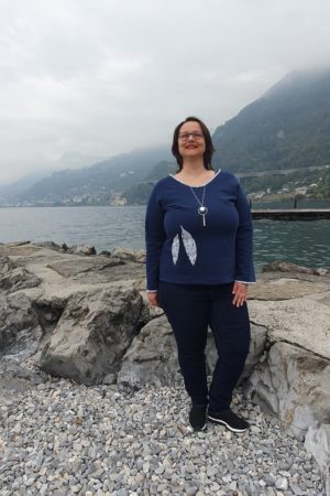 Pull de la gamme Patch'mode, en bleu denim, et motif plumes sur le devant assorti au biais de l'encolure